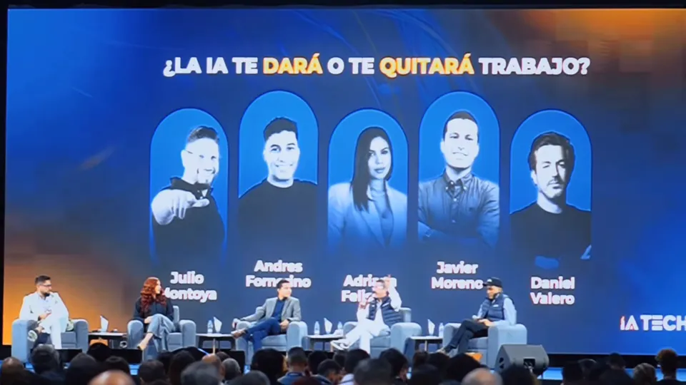 Panel en tarima bajo la pantalla «¿La IA te dará o te quitará trabajo?»