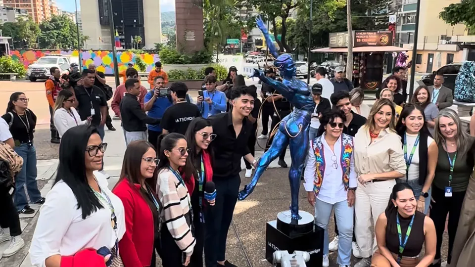 Asistentes sonrientes posan junto a la escultura azul de Keia
